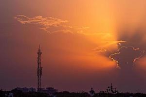 pôr do sol colorido e torre de rádio foto