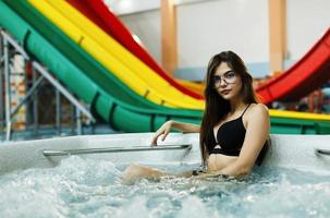 a linda garota sentada na piscina foto