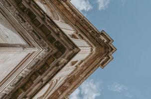 fotografia de baixo ângulo de um edifício bege sob o céu azul foto