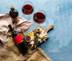 garrafa de vinho e taças com mistura de queijo
