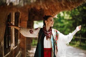 linda garota em um vestido tradicional ucraniano dançando e sorrindo foto