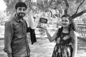 casal indiano posando para ensaio de maternidade. o casal está posando em um gramado com grama verde e a mulher está vacilando sua barriga no jardim lodhi em nova delhi, índia - preto e branco foto