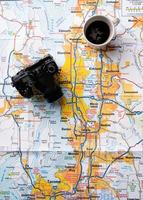 acessórios de viajante flat lay no mapa, câmera e xícara de café foto