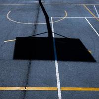 sombra de aro de basquete de rua na quadra de esportes foto