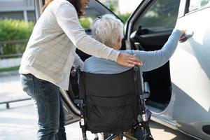 paciente asiático sênior ou idosa senhora sentada na cadeira de rodas preparar chegar ao carro dela, conceito médico forte saudável. foto