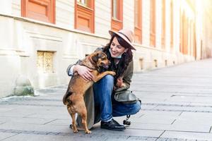 mulher durante isolamento pandêmico passeando com seu cachorro na rua. menina estilosa com cachorro engraçado descansando, abraçando e se divertindo, momentos fofos. foto