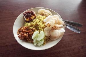 nasi kuning, arroz de cor amarela. deliciosa comida indonésia. foto