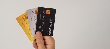 mão é segurar três cartões de crédito em fundo branco. foto