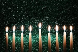 velas de Chanucá. candelabro tradicional com velas acesas em fundo preto. celebrando o feriado religioso judaico.