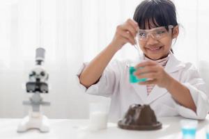 educação, ciência, química e conceito de crianças - crianças ou estudantes com tubo de ensaio fazendo experimento no laboratório da escola foto