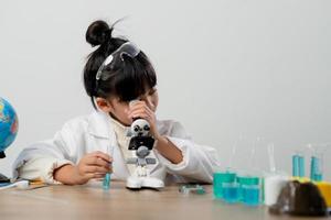 educação, ciência, química e conceito de crianças - crianças ou estudantes com tubo de ensaio fazendo experimento no laboratório da escola foto