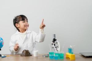 educação, ciência, química e conceito de crianças - crianças ou estudantes com tubo de ensaio fazendo experimento no laboratório da escola foto