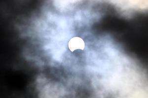 eclipse solar - a lua bloqueia parcialmente o sol de um observador na terra. foto