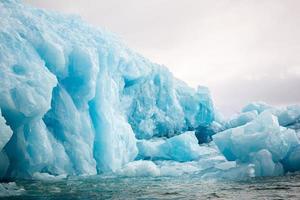 um iceberg azul flutuando no mar em svalberg foto