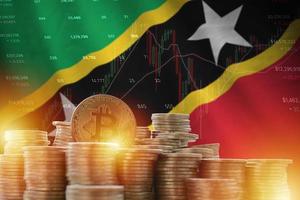 Bandeira de São Cristóvão e Nevis e grande quantidade de moedas de bitcoin douradas e gráfico de plataforma de negociação. moeda criptografada foto