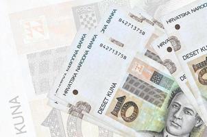 10 notas de kuna croatas estão na pilha no fundo da grande nota semitransparente. apresentação abstrata da moeda nacional foto