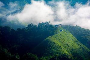 belas montanhas sob a névoa da manhã, neblina e nuvem tropical paisagem acolhedora viajantes. foto