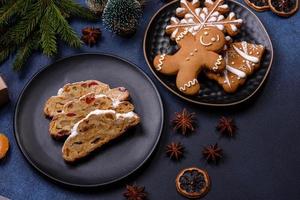 deliciosa torta festiva de ano novo com frutas cristalizadas, maçapão e nozes em um fundo escuro de concreto foto