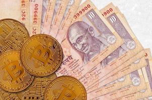 notas de 10 rúpias indianas e bitcoins dourados. conceito de investimento em criptomoeda. mineração ou negociação de criptografia foto