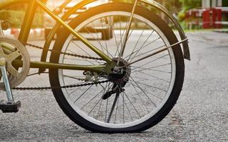 roda traseira da bicicleta que é plana e estacionada na calçada ao lado da estrada. foto