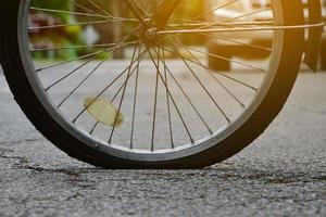 roda traseira da bicicleta que é plana e estacionada na calçada ao lado da estrada. foto