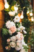 lindos buquês de flores no fundo de uma placa de madeira e guirlandas foto