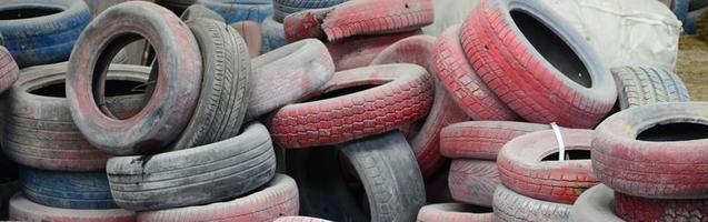 uma foto de muitos pneus usados velhos deixados em um depósito de lixo