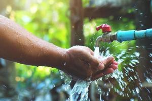 O conceito de boa gestão da água permite ter água limpa para usar para sempre. a mão que segura a água com alegria foto
