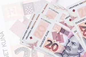 20 notas de kuna croatas estão na pilha no fundo da grande nota semitransparente. apresentação abstrata da moeda nacional foto