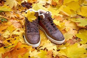 sapatos masculinos quentes preparados para a estação fria e chuvosa, pisando em folhas caídas. foto