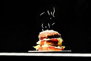 Hambúrguer saboroso fresco isolado em fundo preto foto