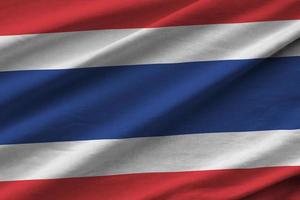 bandeira da tailândia com grandes dobras acenando perto sob a luz do estúdio dentro de casa. os símbolos e cores oficiais no banner foto