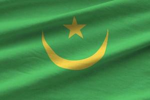 bandeira da mauritânia com grandes dobras acenando perto sob a luz do estúdio dentro de casa. os símbolos e cores oficiais no banner foto