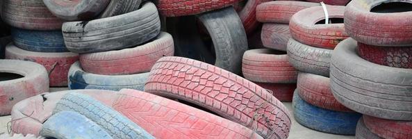 uma foto de muitos pneus usados velhos deixados em um depósito de lixo
