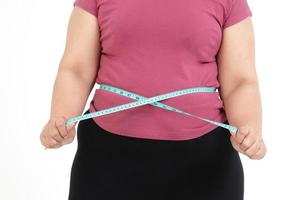 mulheres asiáticas gordas usam uma fita métrica azul. meça o tamanho da sua barriga. conceito de perda de peso, problemas de saúde de pessoas obesas. fundo branco. isolado. foto
