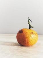 esta é uma foto de uma pequena laranja em uma mesa de madeira.