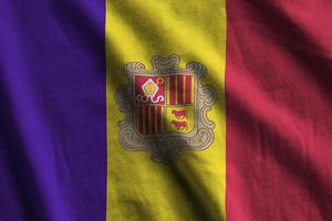 bandeira de andorra com grandes dobras acenando de perto sob a luz do estúdio dentro de casa. os símbolos oficiais e cores no banner foto