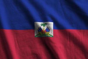 bandeira do haiti com grandes dobras acenando de perto sob a luz do estúdio dentro de casa. os símbolos oficiais e cores no banner foto