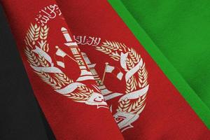 bandeira do afeganistão com grandes dobras acenando de perto sob a luz do estúdio dentro de casa. os símbolos oficiais e cores no banner foto