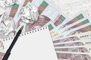 10 contas de zloty polonês e bolas de papel amassado com bloco de notas em branco. ideias ruins ou menos do conceito de inspiração. procurando ideias para investimento foto