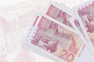 20 notas de kuna croatas estão na pilha no fundo da grande nota semitransparente. apresentação abstrata da moeda nacional foto