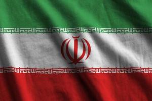 bandeira do irã com grandes dobras acenando de perto sob a luz do estúdio dentro de casa. os símbolos oficiais e cores no banner foto