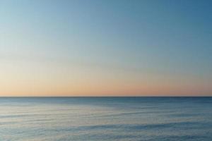linha horizontal entre o mar e o céu ao pôr do sol. foto