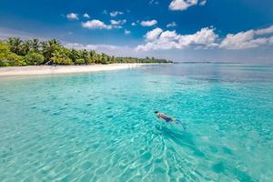 casal caucasiano de turistas mergulha em águas turquesas cristalinas perto da ilha maldivas. ilha tropical e conceito de mar. área de snorkel em recifes de corais com mergulho em casal foto