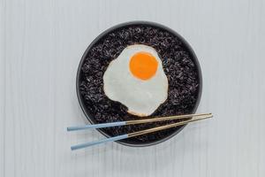 comida saudável arroz preto na tigela tem ovo frito foto