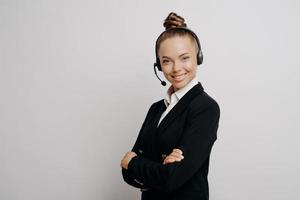 mulher de negócios amigável no fone de ouvido em terno escuro pronto para conferência na web foto