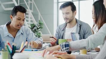 grupo de empresários vestidos casualmente, discutindo ideias no escritório. profissionais criativos reunidos na mesa de reunião para discutir as questões importantes do novo projeto de startup de sucesso. foto