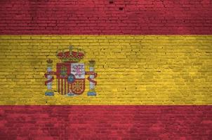 bandeira da espanha retratada em cores de tinta na parede de tijolos antigos. banner texturizado em fundo de alvenaria de parede de tijolo grande foto