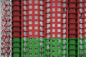 bandeira da bielorrússia retratada em cores de tinta em prédio residencial de vários andares em construção. banner texturizado no fundo da parede de tijolos foto