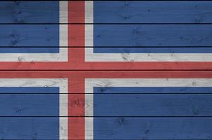 bandeira da islândia retratada em cores brilhantes de tinta na parede de madeira velha. banner texturizado em fundo áspero foto